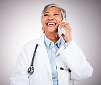 Doctor, phone call and woman in studio for communication, consulting or telehealth contact on grey background. Happy mature medical surgeon laugh for mobile consultation, support or healthcare advice