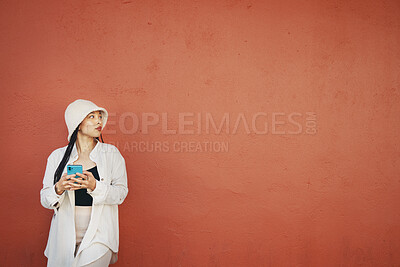 Buy stock photo Thinking, wall and woman with phone in a city for travel, search or location map on orange background. Smartphone, app and lady fashion influencer outdoor on social media, blog, or podcast idea