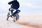 Desert, dust or driver driving motorcycle for action, adventure or fitness with performance or adrenaline. Sand, back or sports athlete on motorbike on dunes for training, exercise or race challenge