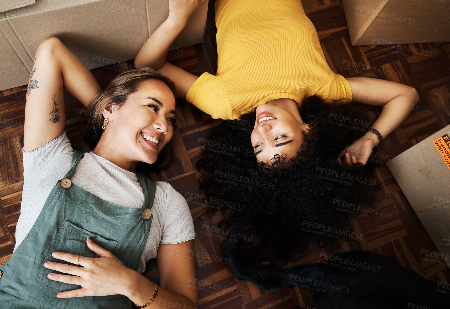 Buy stock photo Top view, lesbian and couple with boxes, homeowners and achievement with love, bonding and property. Queer people, lgbtq or happy women on the ground, new apartment and conversation with real estate