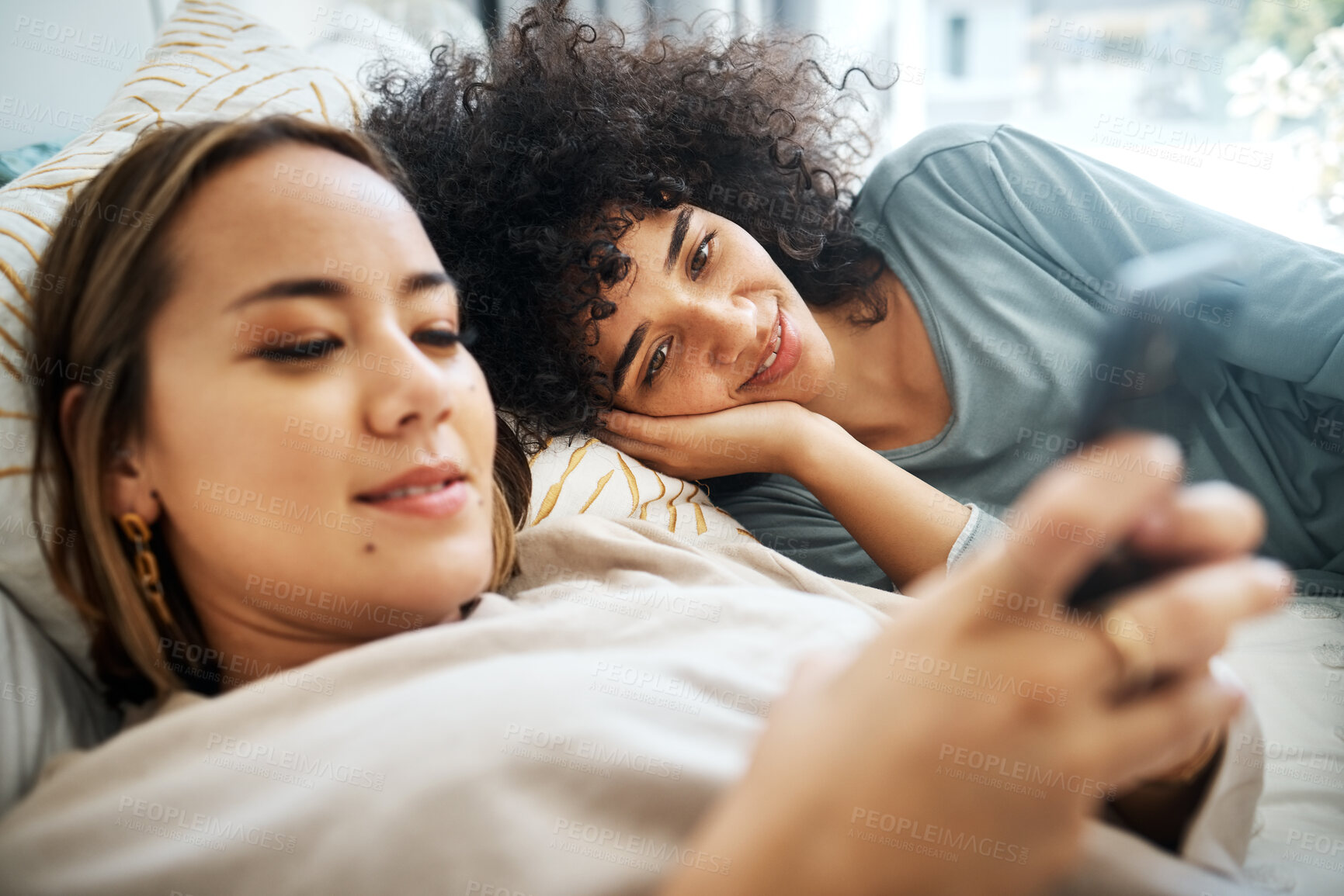 Buy stock photo Phone, social media and an lgbt couple in bed together in the morning for communication or to relax. Love, lesbian and a woman watching a movie or video with her girlfriend in the home bedroom