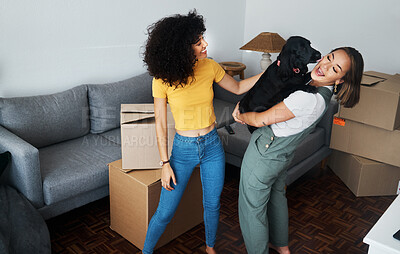 Buy stock photo Dog, smile and gay couple in new home, play and bonding together in living room. Happy lesbian women with pet in house, apartment and moving in to real estate property, having fun and carrying animal