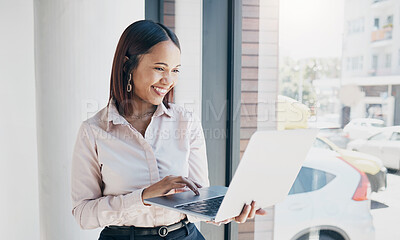 Buy stock photo Woman in office with smile, holding laptop and reading email, HR schedule or online for feedback at window. Internet, networking and communication on website, happy person and human resources agency