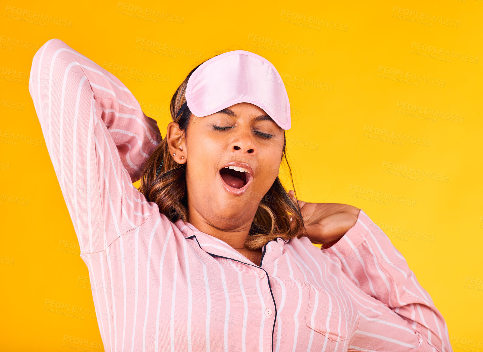 Buy stock photo Wake up, yawn and a woman on a yellow background in pyjamas for sleeping, tired and in the morning. Fatigue, young and a girl or person in clothes for rest, comfort and a nap in a studio for night