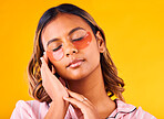 Woman, eye mask and beauty with skincare, dermatology and cosmetic product on yellow background. Peace, calm and self care treatment with patch, facial for antiaging with glow and wellness in studio