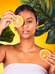 Woman, portrait and orange in beauty for vitamin C, skincare or detox with leaves against a studio background. Female person or model with natural organic citrus fruit or food for healthy nutrition