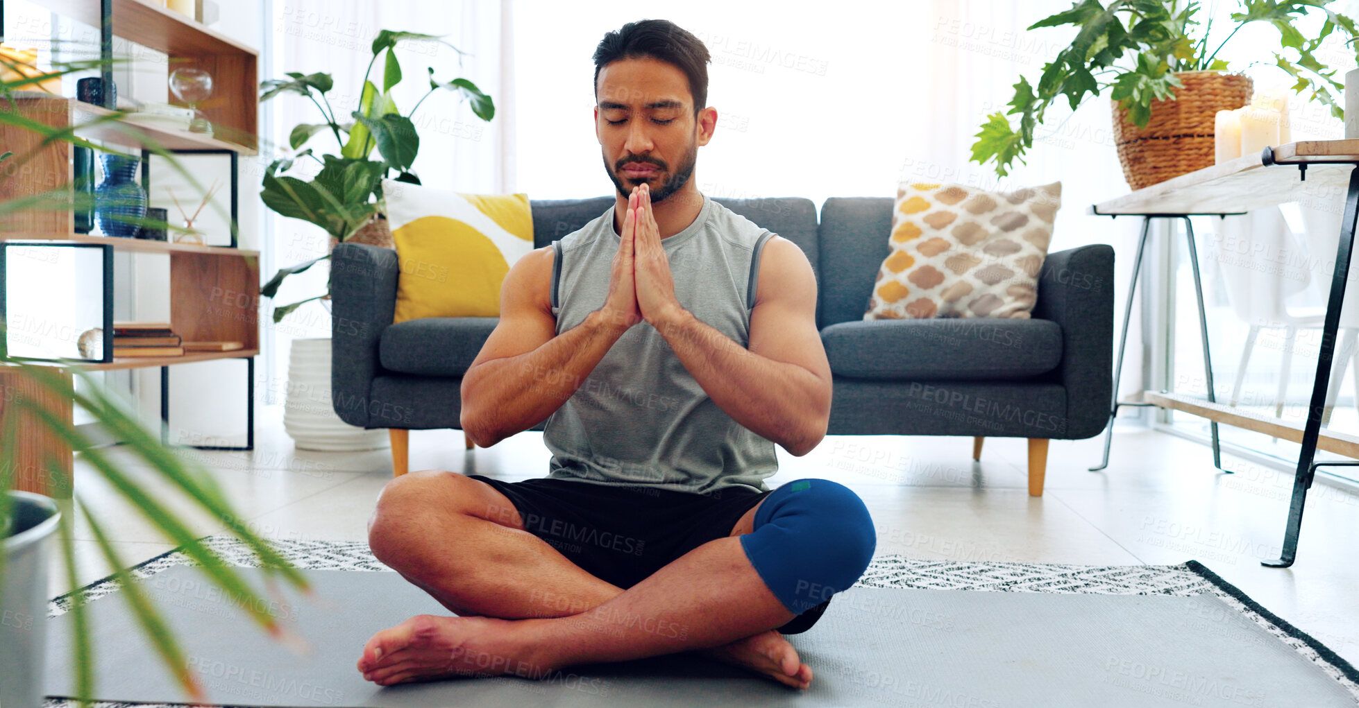 Buy stock photo Man, meditation and lotus on floor, home and peace with silence for wellness, relax and spiritual growth. Asian guy, zen and mindfulness for chakra balance, health and yoga in living room at house