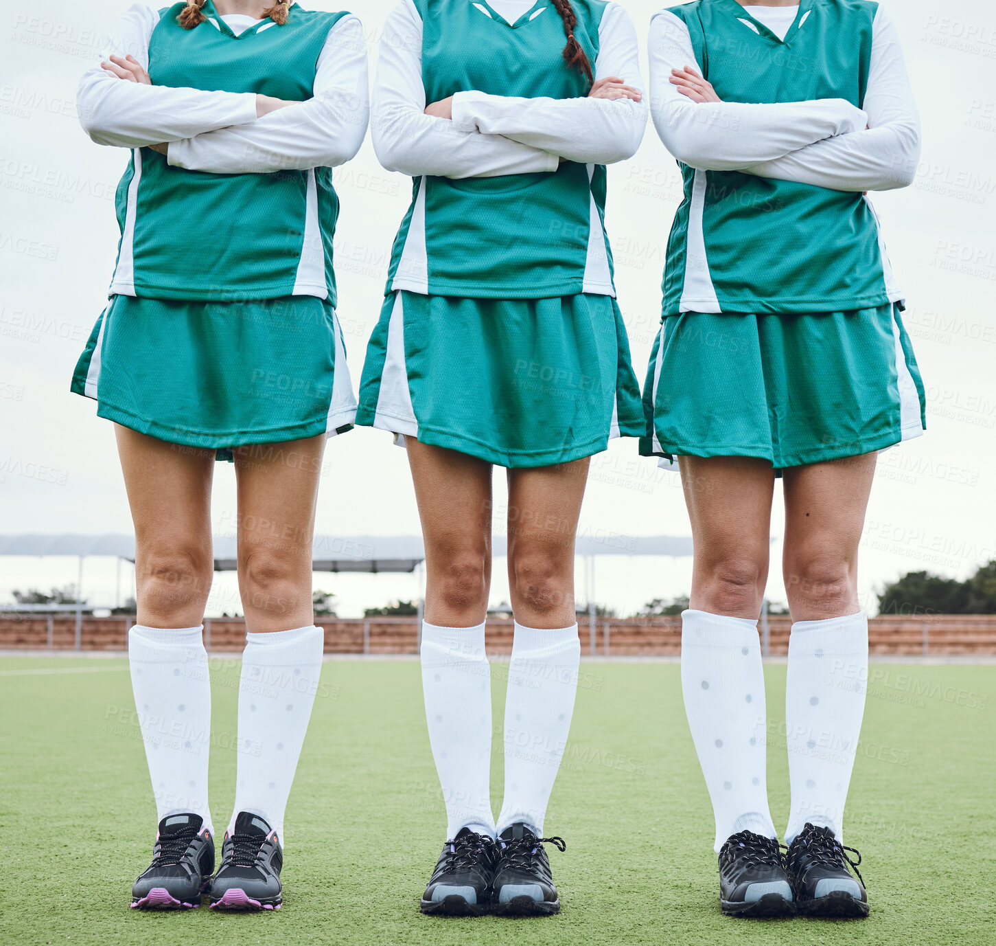 Buy stock photo Legs, arms crossed and a woman hockey team outdoor on a field for a game or competition together in summer. Fitness, feet and sports people on a pitch of a grass for training or teamwork on match day