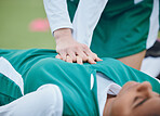 Hands, first aid and cpr with a hockey player on a field to save a player on her team after an accident. Fitness, heart and emergency attack with a woman helping her friend on a field of grass