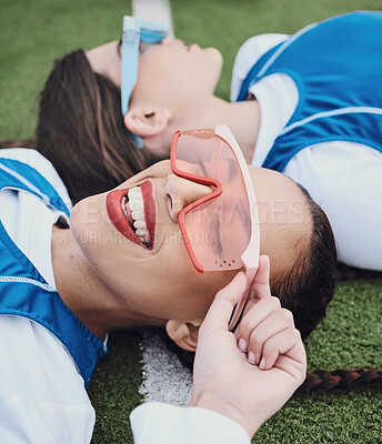 Buy stock photo Friends, sports and laying on field, break and closeup of sunglasses, smile and relax for practice, training and workout. Happy people, playful and lazy for exercise, fashion and accessories for fun