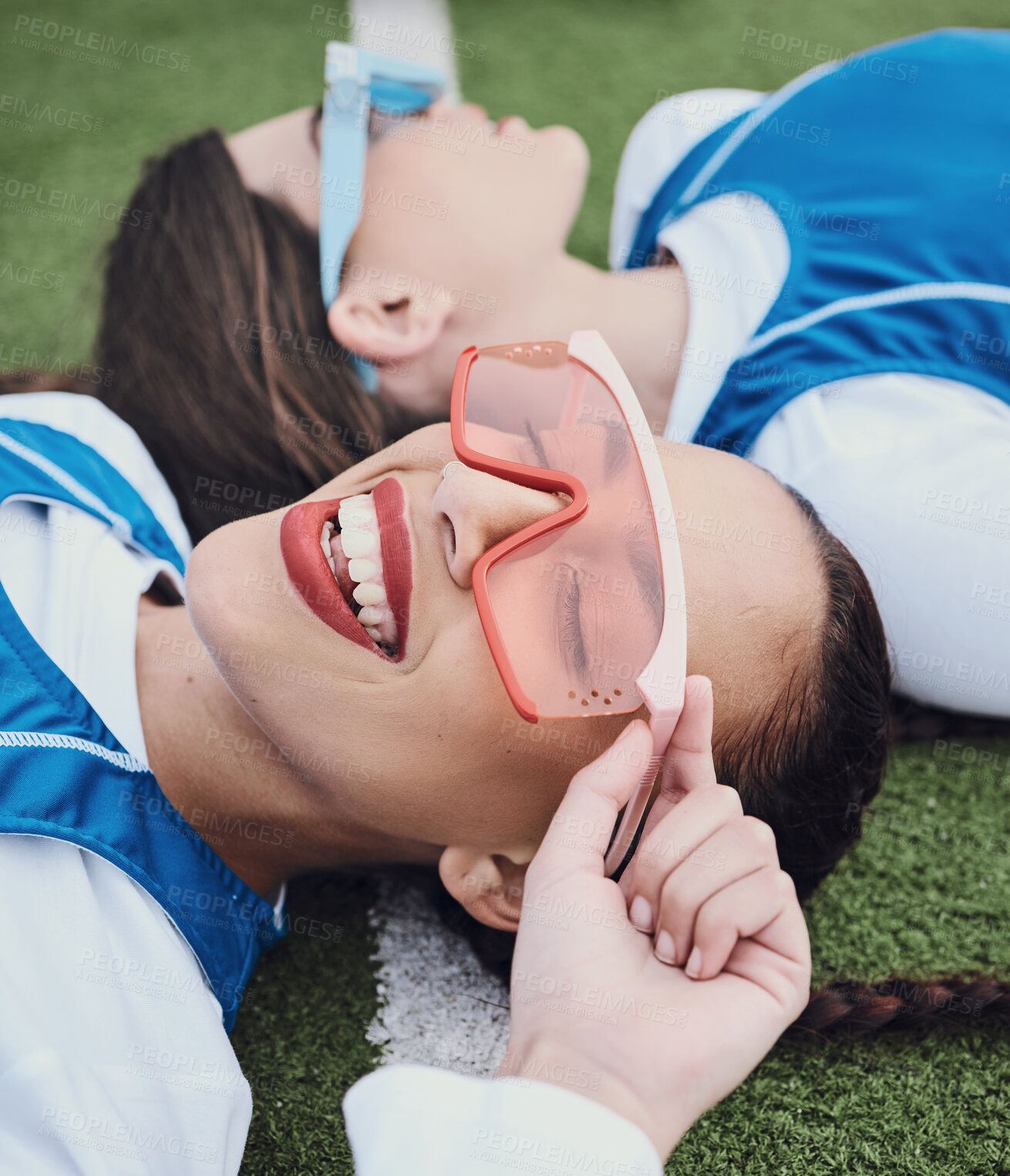 Buy stock photo Friends, sports and laying on field, break and closeup of sunglasses, smile and relax for practice, training and workout. Happy people, playful and lazy for exercise, fashion and accessories for fun