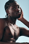 Black man, beauty with grooming and face, shirtless in studio and isolated on blue background. Hygiene, skincare and African model with muscle, clean dermatology and natural cosmetics in portrait