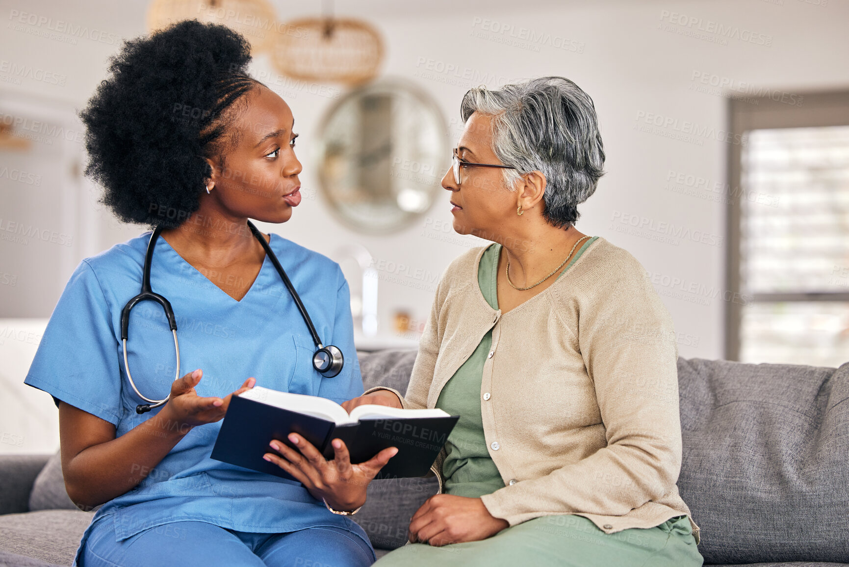 Buy stock photo Bible, religion and assisted living caregiver with an old woman in a retirement home together. Healthcare, christian faith or belief with a nurse or volunteer reading to a senior patient in a house