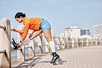 Woman, roller skates and outdoor in park, stretching legs and training for contest, fitness or health by ocean. Gen z girl, skating and walk for exercise, workout or metro road by sea in Cape Town