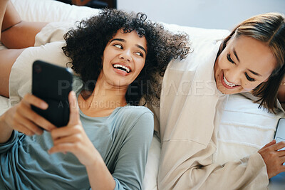 Buy stock photo Home, lesbian couple and women with a phone, digital app and typing with social media, relax and romance. Communication, queer people and happy girls with a cellphone, mobile user and meme with post