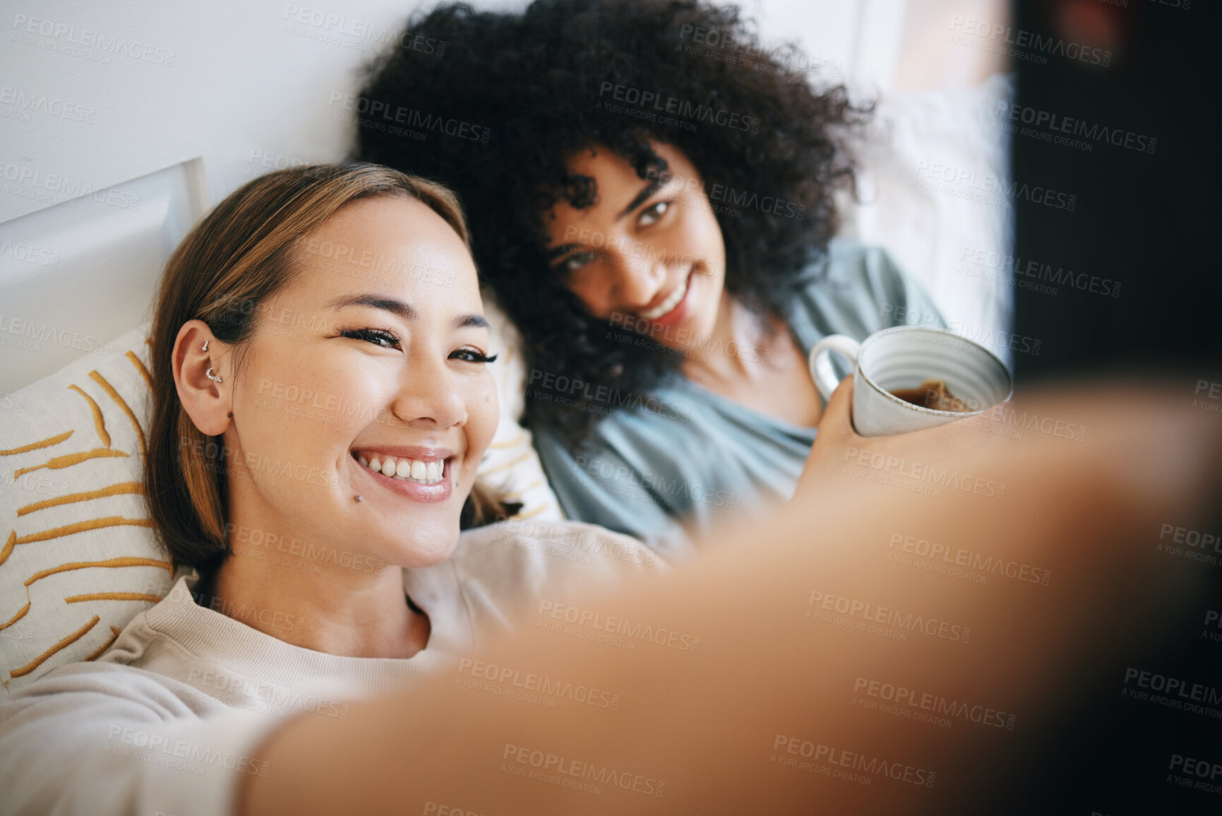 Buy stock photo Love, selfie and lesbian couple relaxing on bed for bonding together in the morning on weekend. Smile, happy and young interracial lgbtq women taking a picture in bedroom of modern apartment or home.