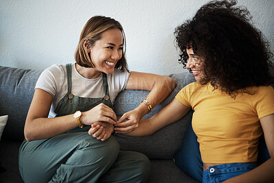 Buy stock photo Conversation, happy and lesbian couple relaxing on a sofa in the living room talking and bonding. Love, communication and young interracial lgbtq women speaking and resting together in lounge at home