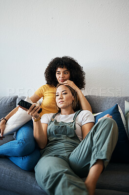 Buy stock photo Love, television and a lesbian couple watching a movie on a sofa in the living room of their home together. Relax, LGBT and a woman with her girlfriend enjoying series on a streaming service