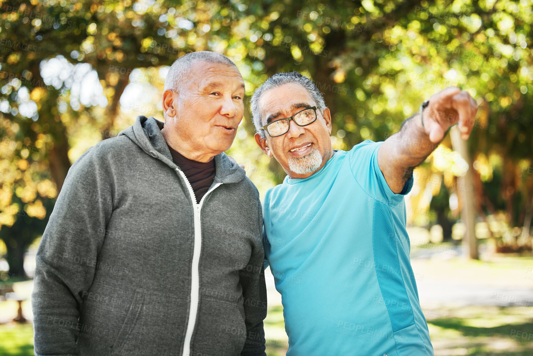 Buy stock photo Mature, men and pointing while talking at park for fitness, health and wellness on retirement. Elderly, friends or people in discussion, embrace and expression on face while resting from exercise