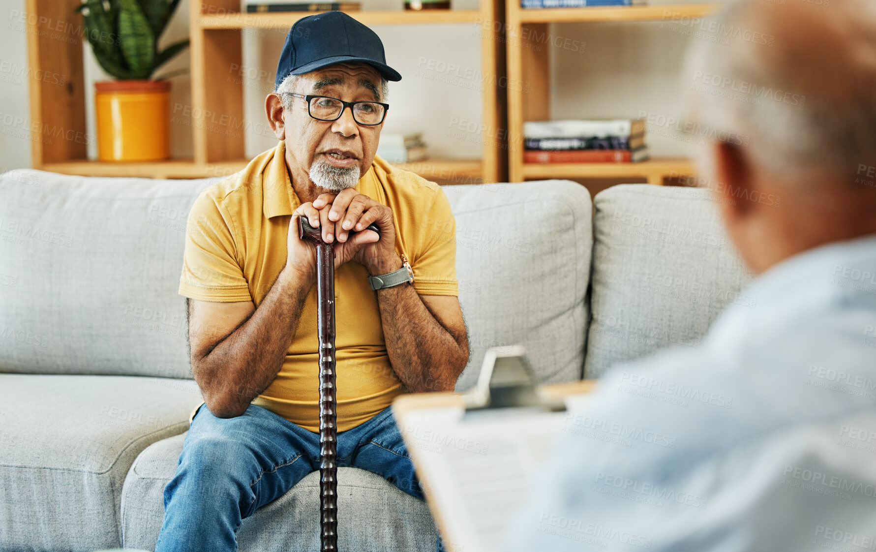 Buy stock photo Doctor, consultation and senior man on sofa with walking stick or discussion of physical therapy and checklist. Therapist, consulting and talking to elderly patient on couch in rehabilitation office