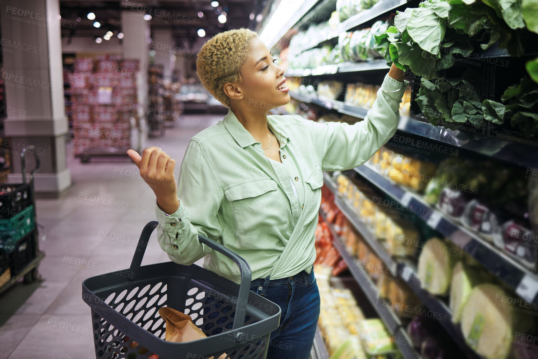 Buy stock photo Woman, grocery shopping and vegetables choice, discount and sale or wholesale promotion of healthy food in basket. Happy African customer with spinach in retail, convenience store or supermarket deal