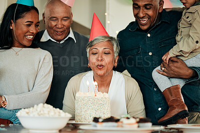 Buy stock photo Happy birthday, candles or grandma in home for a family celebration, bond or growth together. Blow, senior lady or excited grandparents with cake, support or child at a fun party or special event