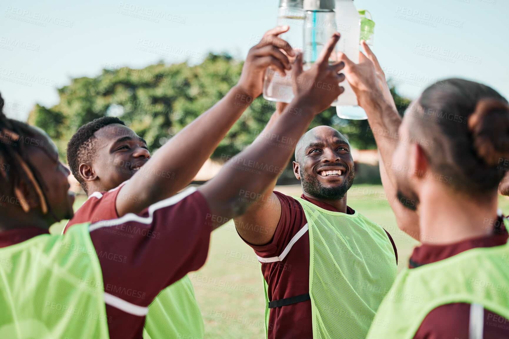 Buy stock photo Soccer team, water bottle and cheers with teamwork, achievement and community on grass field. Fitness, workout and sport training of men group with smile and celebration from game outdoor with drink