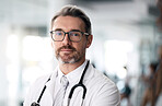 Serious doctor, portrait and man with glasses in hospital for health, wellness or career in medicine. Face, medical professional and confident surgeon, expert therapist or mature physician in Canada