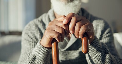 Closeup, senior and hands of man with cane for support, walking help and aging. Morning, house and elderly person with gear for a walk on the living room sofa for healthcare and holding for strength