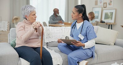 Healthcare, consultation and nurse with senior woman in the living room of the retirement home. Medical, checkup and female caregiver speaking to elderly patient with walking cane in nursing facility