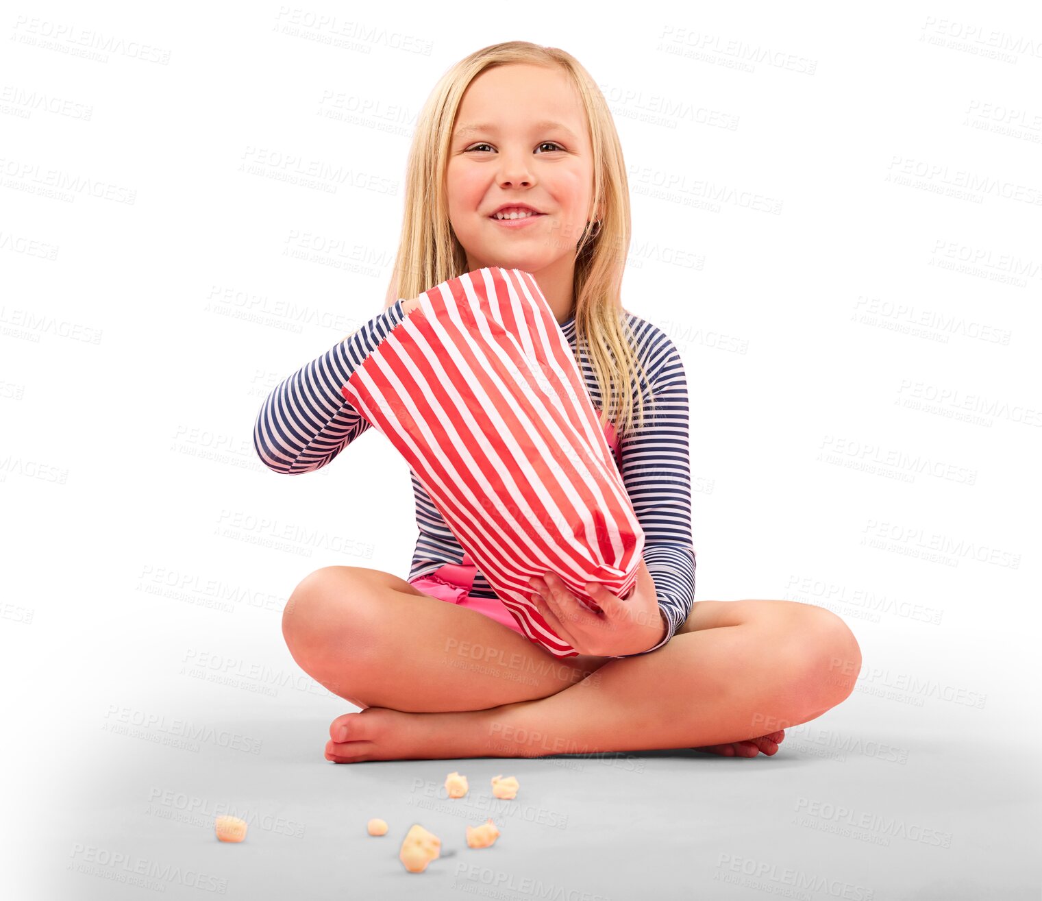 Buy stock photo Happy little girl, sitting and eating popcorn, snack or luxury for movie isolated on a transparent PNG background. Female person, child or hungry kid smile with food in paper bag or watching TV