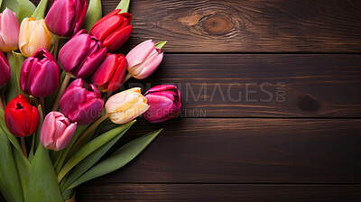 Top view of colourful, fresh tulips on brown wooden table with copy space.