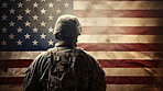 Silhouette of soldier standing in front of American flag hanging on the wall. Shot from behind. Patriotic duty and pride.