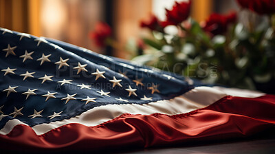 American flag on table with flowers in background. Patriotic symbolism concept.
