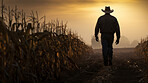 Farmer walking through wheat crop field at sunrise. Silhouette of man with hat