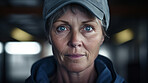 Confident serious mature older woman in warehouse. Worker, supervisor and industrial contractor at project