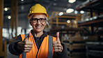 Confident mature older woman with hardhat in shipping warehouse showing thumbsup at camera