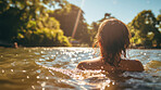 Young women swimming in lake. Warm summers day. Sun flare reflecting on water.