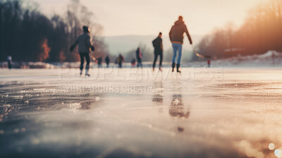Group of people ice skating in city park, at sunset or sunrise. Healthy outdoor winter activity