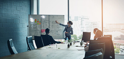 Buy stock photo Shot of an executive giving a whiteboard presentation to a group of colleagues in a boardroom