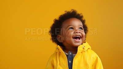 Portrait of a toddler posing against a yellow background. happy smiling girl