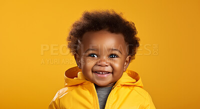 Portrait of a toddler posing against a yellow background. happy smiling boy