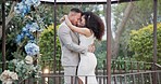 Wedding, bride and groom dancing with hug and happiness at ceremony with life partner and commitment. Marriage, trust and people in interracial relationship, event decor and nature, love and care