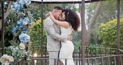 Wedding, bride and groom dancing with hug and happiness at ceremony with life partner and commitment. Marriage, trust and people in interracial relationship, event decor and nature, love and care