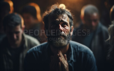 Mature man praying to God in room with others in background. Religious concept.