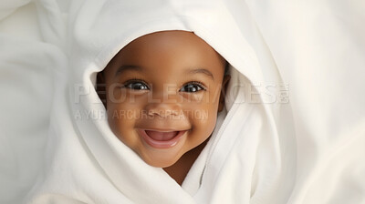 Portrait of a happy baby wrapped in a towel or blanket. Toddler smiling after bath time