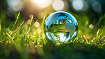 Glass globe on grass in a forest. Sustainable environment and Earth Day concept