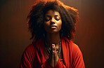 African American woman praying. Hands folded against backdrop. Religion Concept.