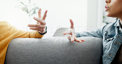 Argument, hands and closeup of couple on a sofa in the living room for cheating, fight or toxic relationship. Conversation, discussion and zoom of man and woman talking for communication at home.