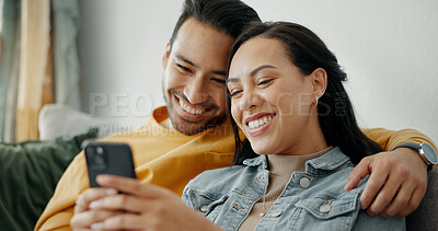 Couple, smile and talking on sofa with phone for social media post, subscription and reading funny notification. Happy man, woman and hug with smartphone for meme, games app and relax in living room